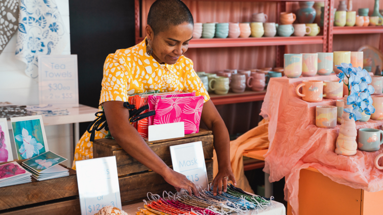 A woman arranges her colourful wares at a stall