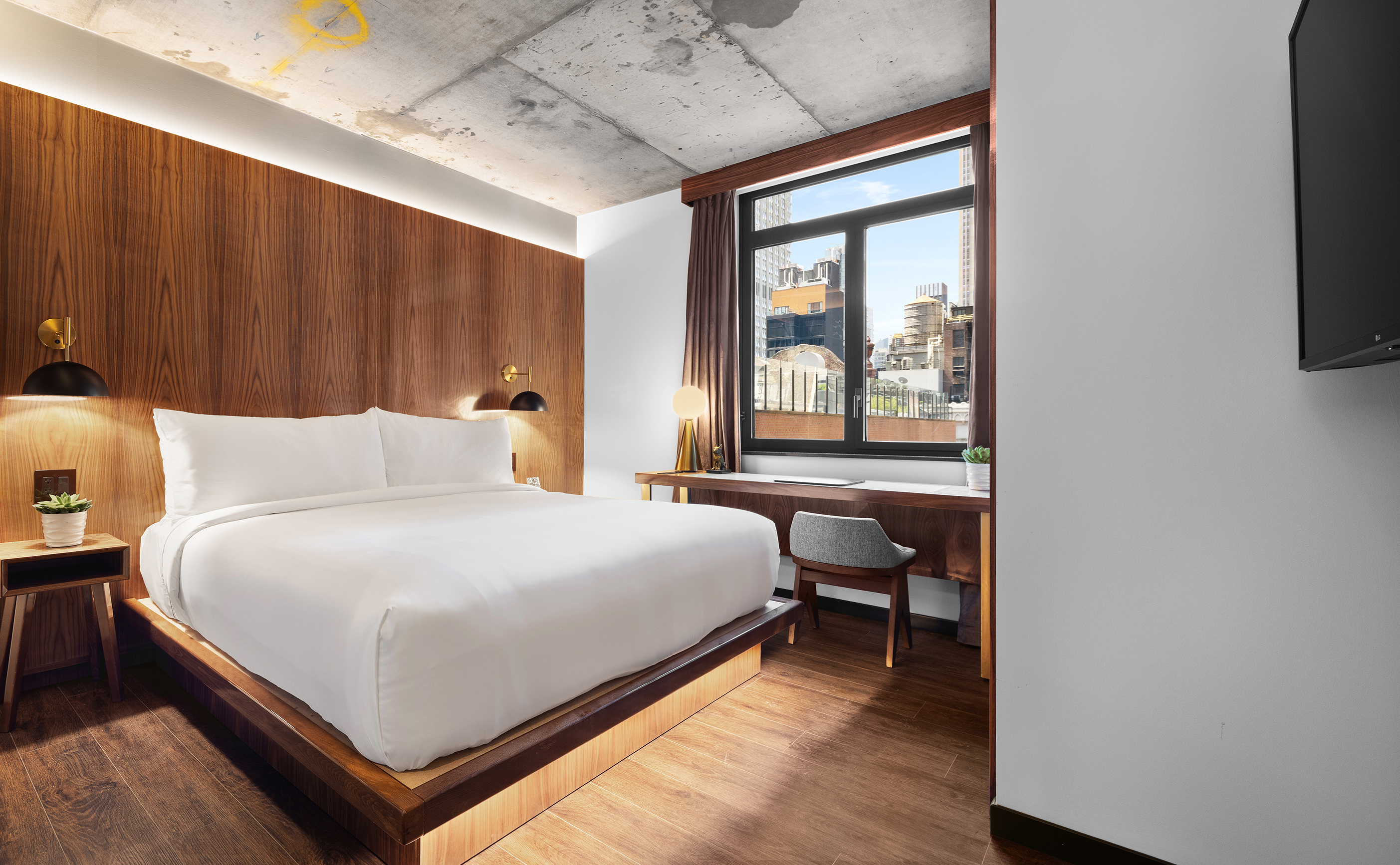 A guest room inside Grayson Hotel with a plush white bed.