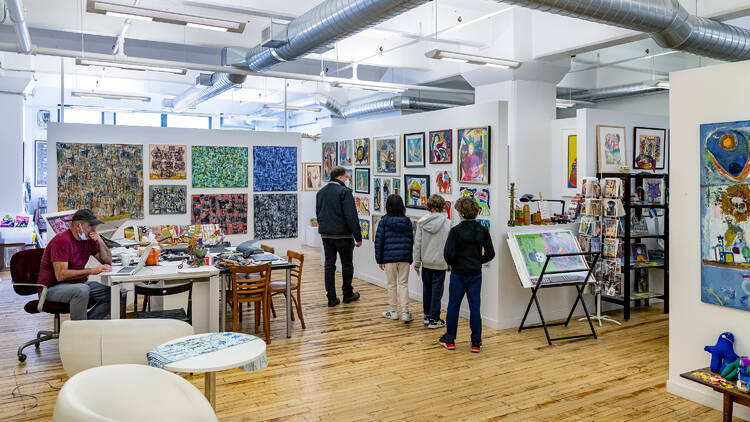 A group of people walks through an art gallery.