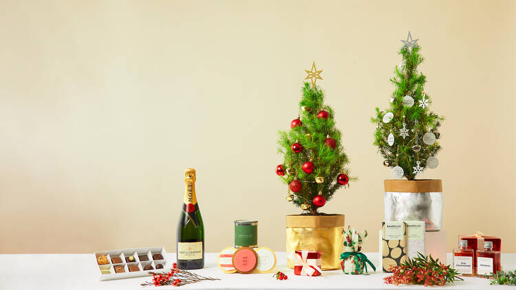 Two mini Christmas trees decorated with treats down the bottom