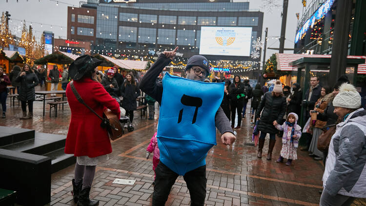 A man in a dreidel costume dances