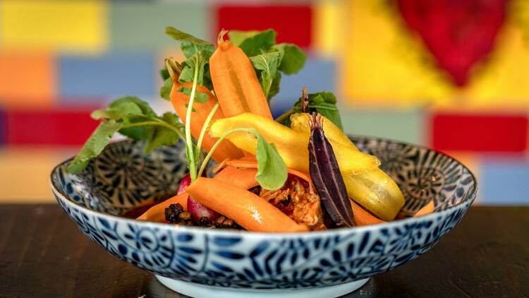 A dish featuring shaved carrots and greens