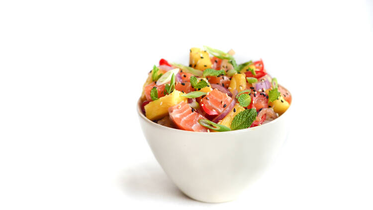 A spicy tuna salmon bowl on a white surface