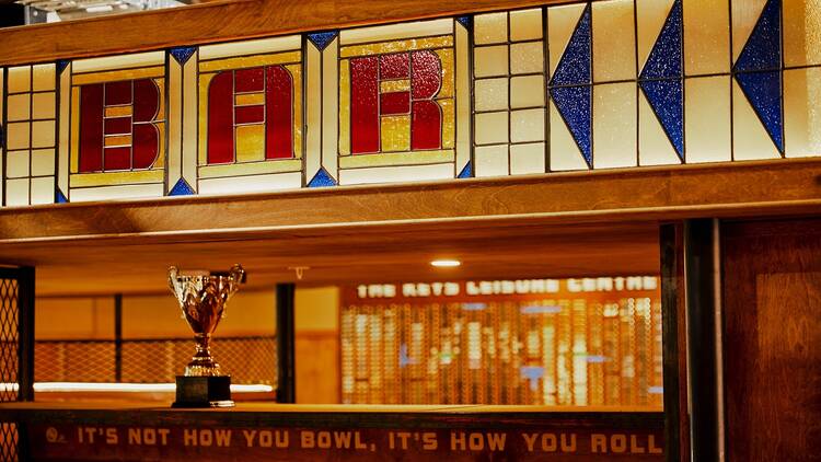 There is a large sign reading "bar" above a trophy and the words "its not how you bowl, its how you roll"