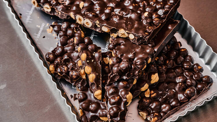 On a silver tray there are slabs of thick dark chocolate filled with hazelnuts