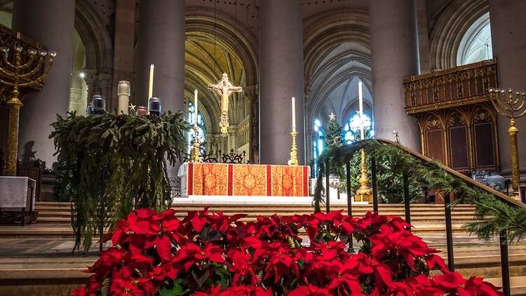 A church altar decorated with red poinsettias.