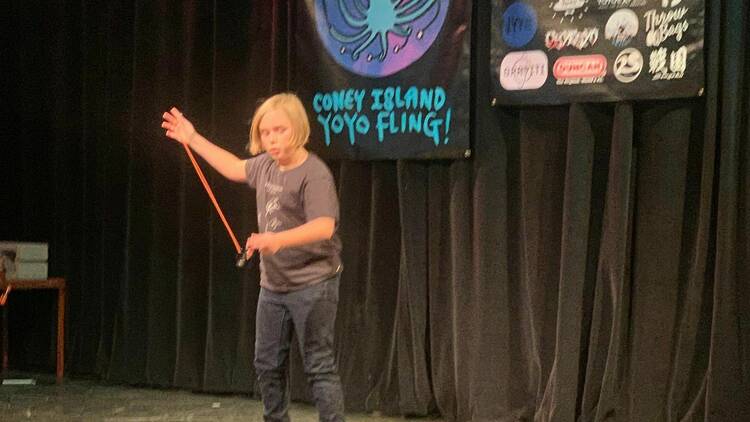 A person on stage does a yo-yo trick.