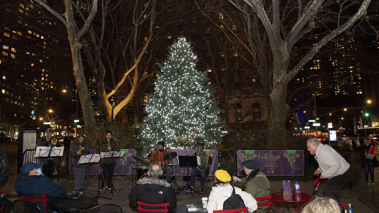 A tree with white lights in Lincoln Square.