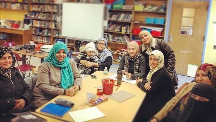 A group of students sits at a table. 