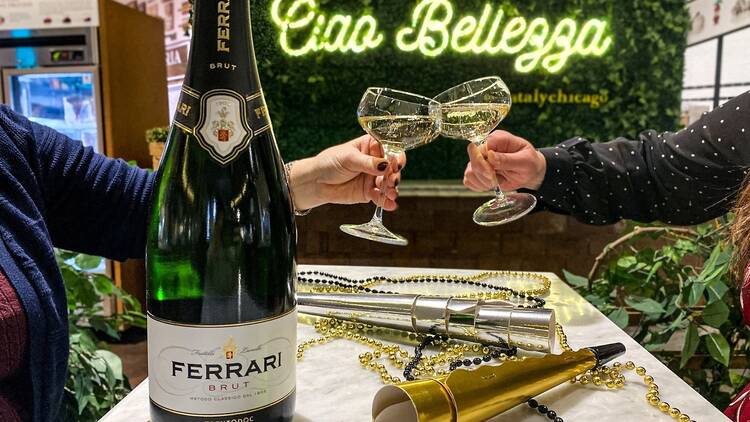 Two people clink glasses of sparkling wine at Eataly