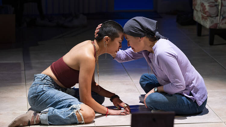 Two women embrace during a prodution of Bald Sisters