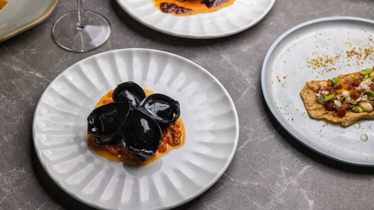 Food is pictured on white plates sitting on a grey marbled tabletop.