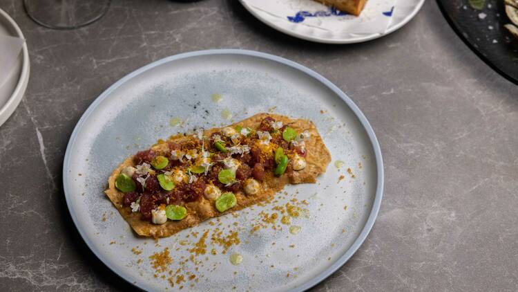 Modern Italian food on a grey plate.