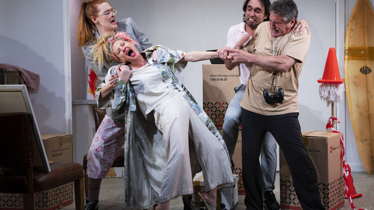Four people on stage in an over-the-top play fight scene.