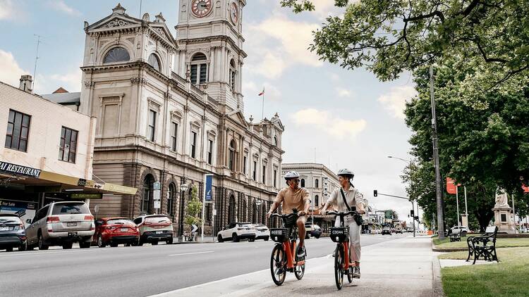 Two cyclists going past the Art Gallery of Ballarat