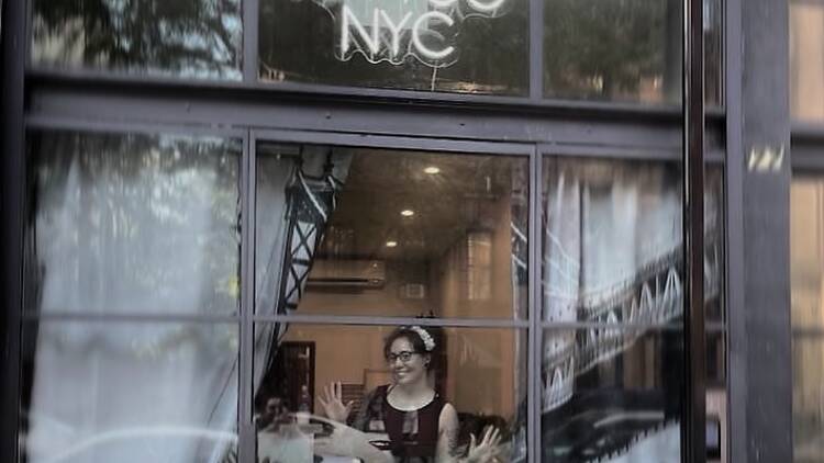Vic Tamian peeks through the window of Victory Tattoo NYC.