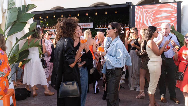 A group of people are laughing at Casa Aperol at Promenade Bondi Beach