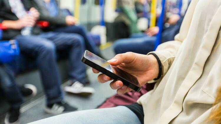 Person using their phone on the tube 