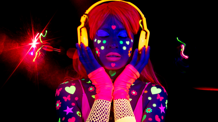 Woman in glow costume wearing headphones