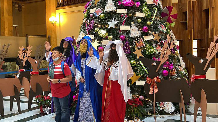 Niños tomándose la foto con los Reyes Magos en el Palacio de los Deseos de Palacio Postal 