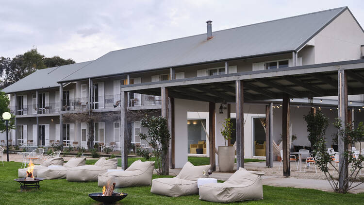 A two-storey boutique hotel with a lawn area and outdoor patio.