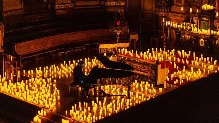 A church filled with candles for a concert.