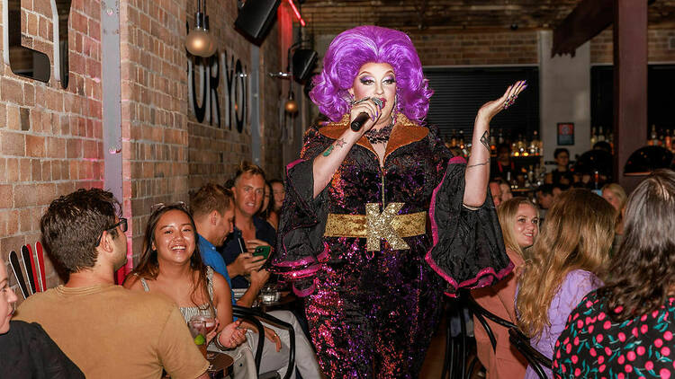 Karen from Finance wearing an amazing purple wig and talking to diners at Chin Chin