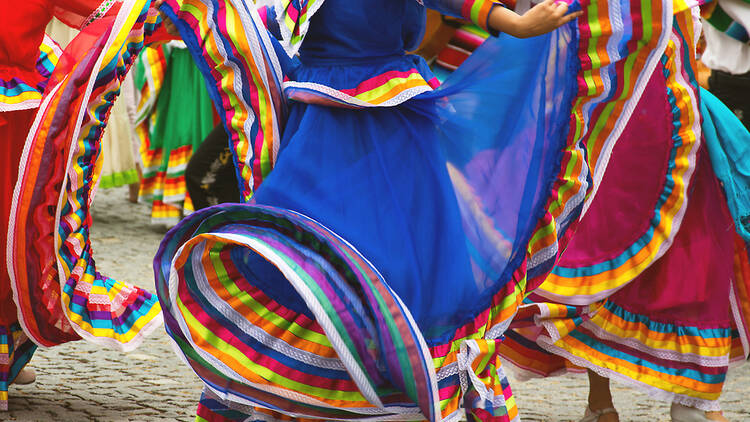 Flamenco dancer is hidden by her brightly colored twirling skirt while she dances. 