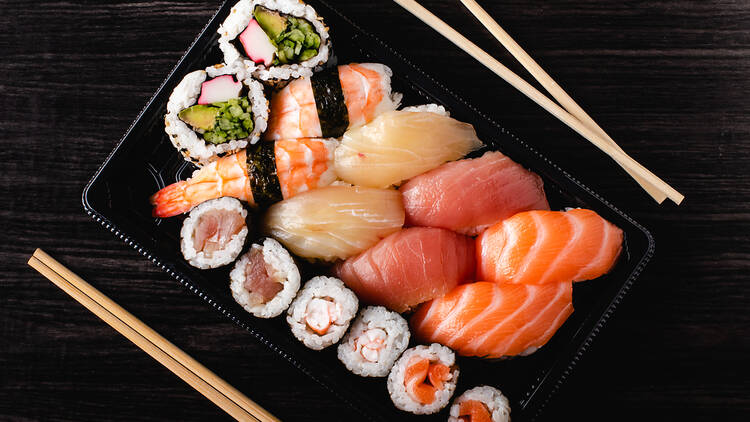 A black tray filled with sushi.