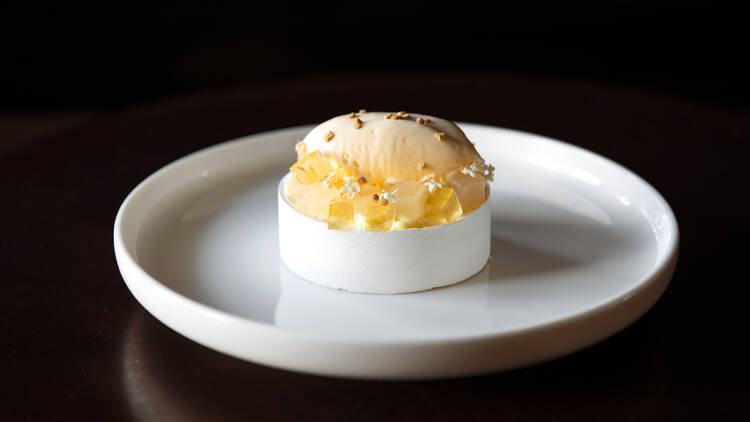 A dessert at Cutler and Co is a white tart on a white plate topped with white cream and jelly 