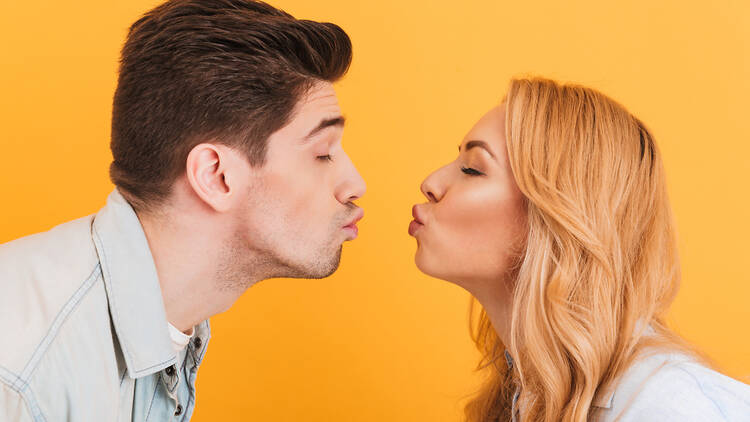 A couple making kissing faces at each other.