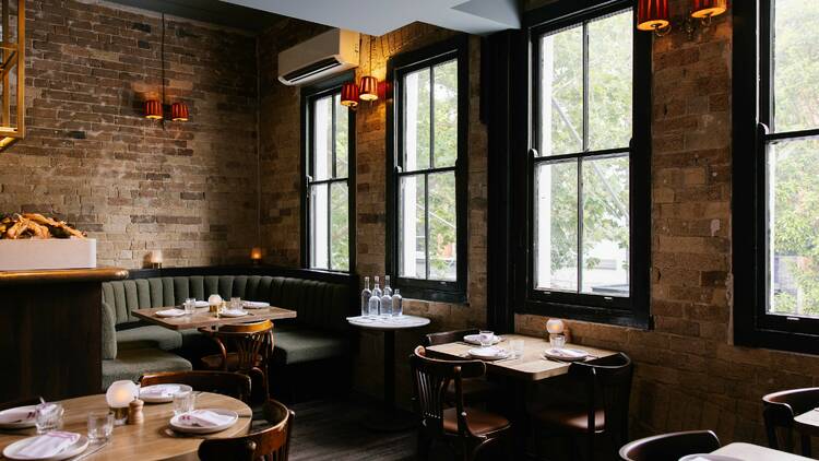 Inside the Rover with wooden tables, green velvet booth and large windows