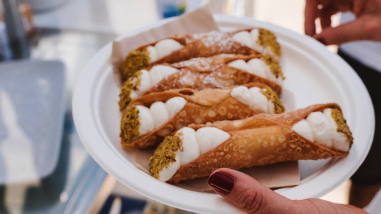 A plate of cannoli filled with ricotta.