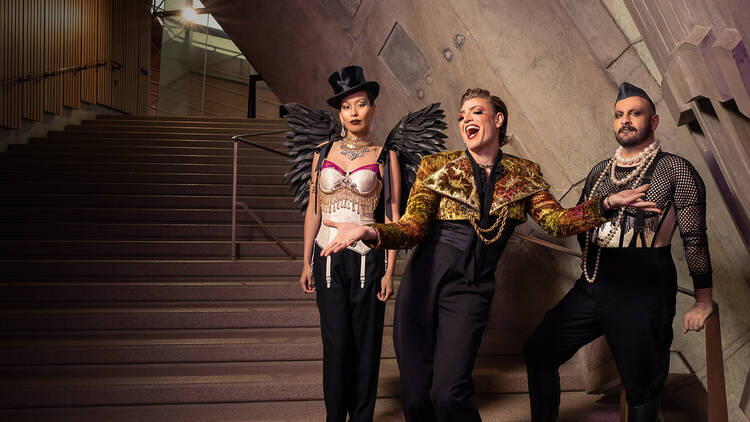 Three drag performers standing in front of the Sydney Opera House
