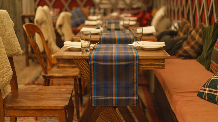 Wooden tables with plaid tablecloths at Gallow Green.