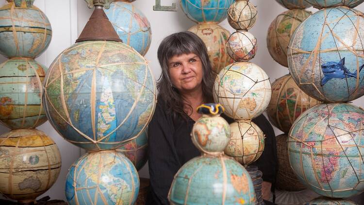 A woman surrounded by world globes