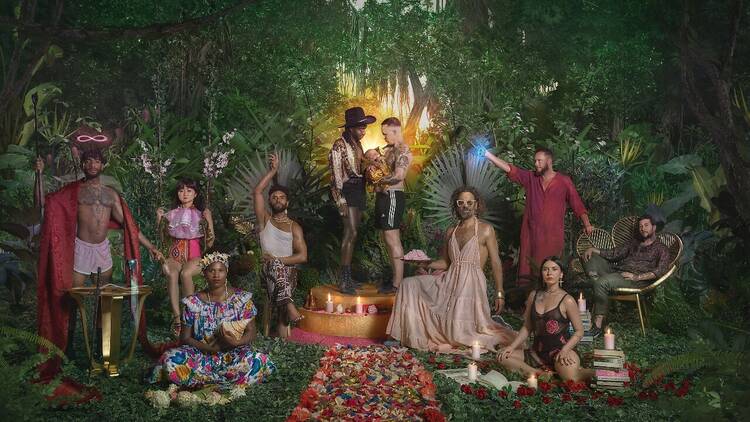 A colourful group of LGBTQIA+ people in a forest setting