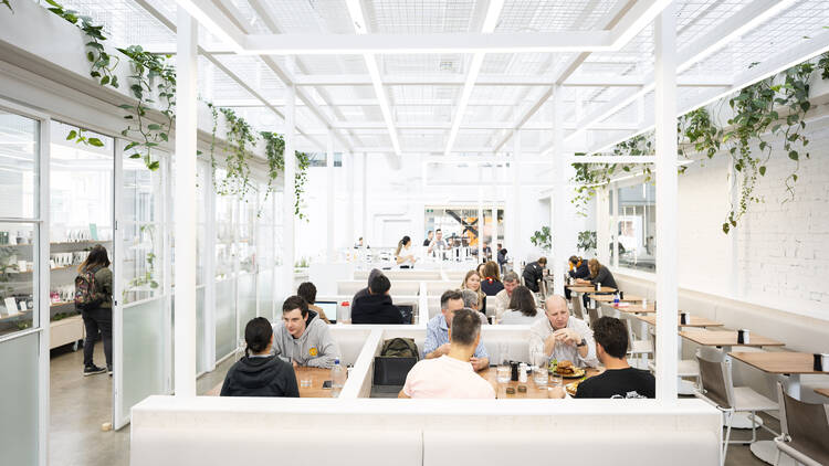 People sitting inside of an industrial-style cafe.