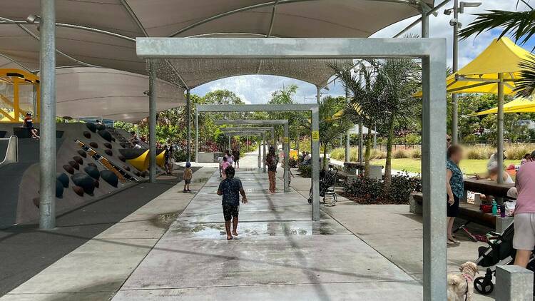 An avenue of water sprinklers in a modern playground 