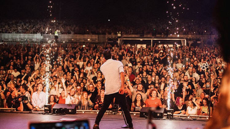 A singer performing on stage in front of a crowd.