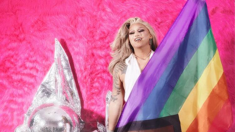 A drag queen with a rainbow flag