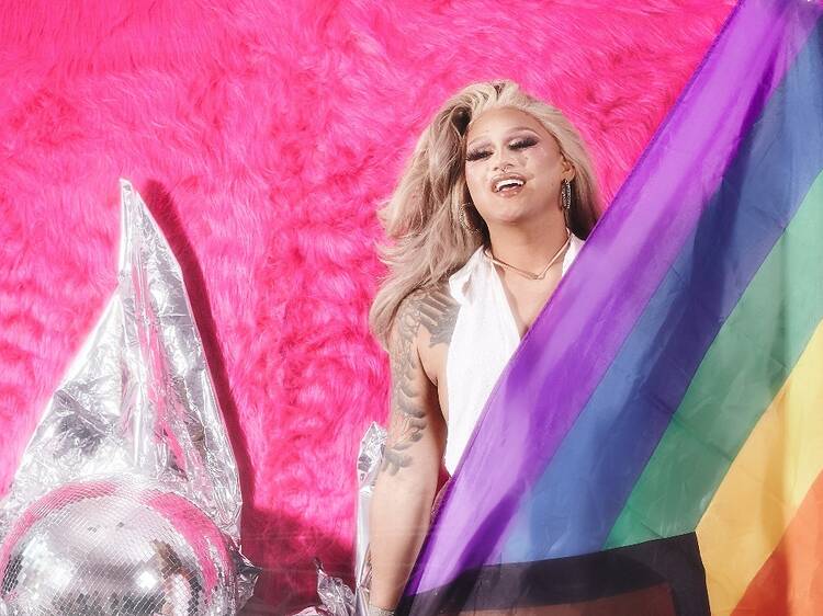 A drag queen with a rainbow flag