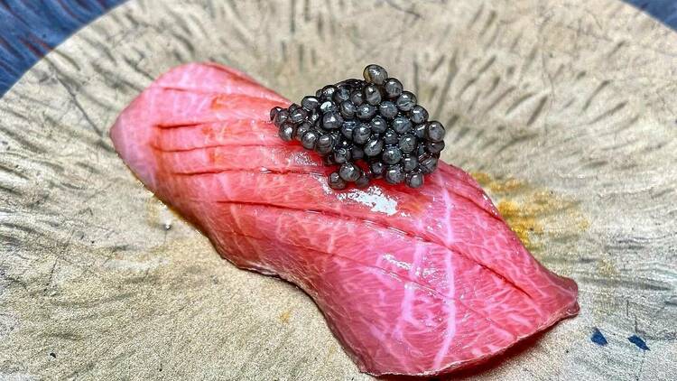 A piece of nigiri with caviar on top