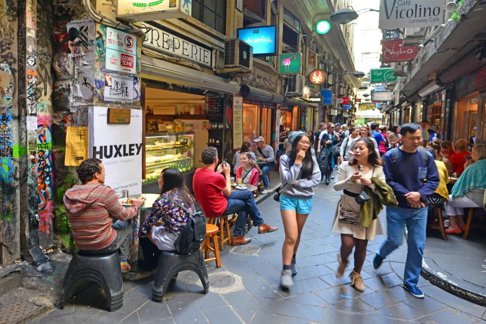 People walking through a crowded Melbourne laneway.