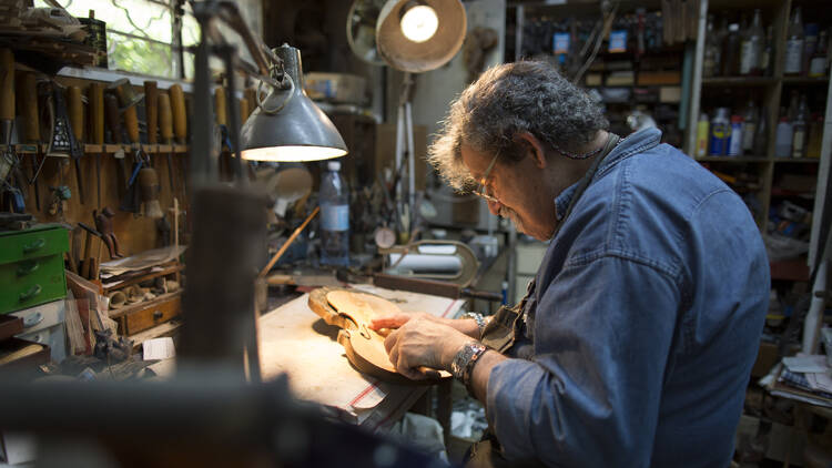 A person works on a violin. 