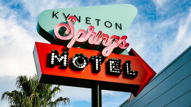 A neon blue, red and pink sign for Kyneton Springs Motel.