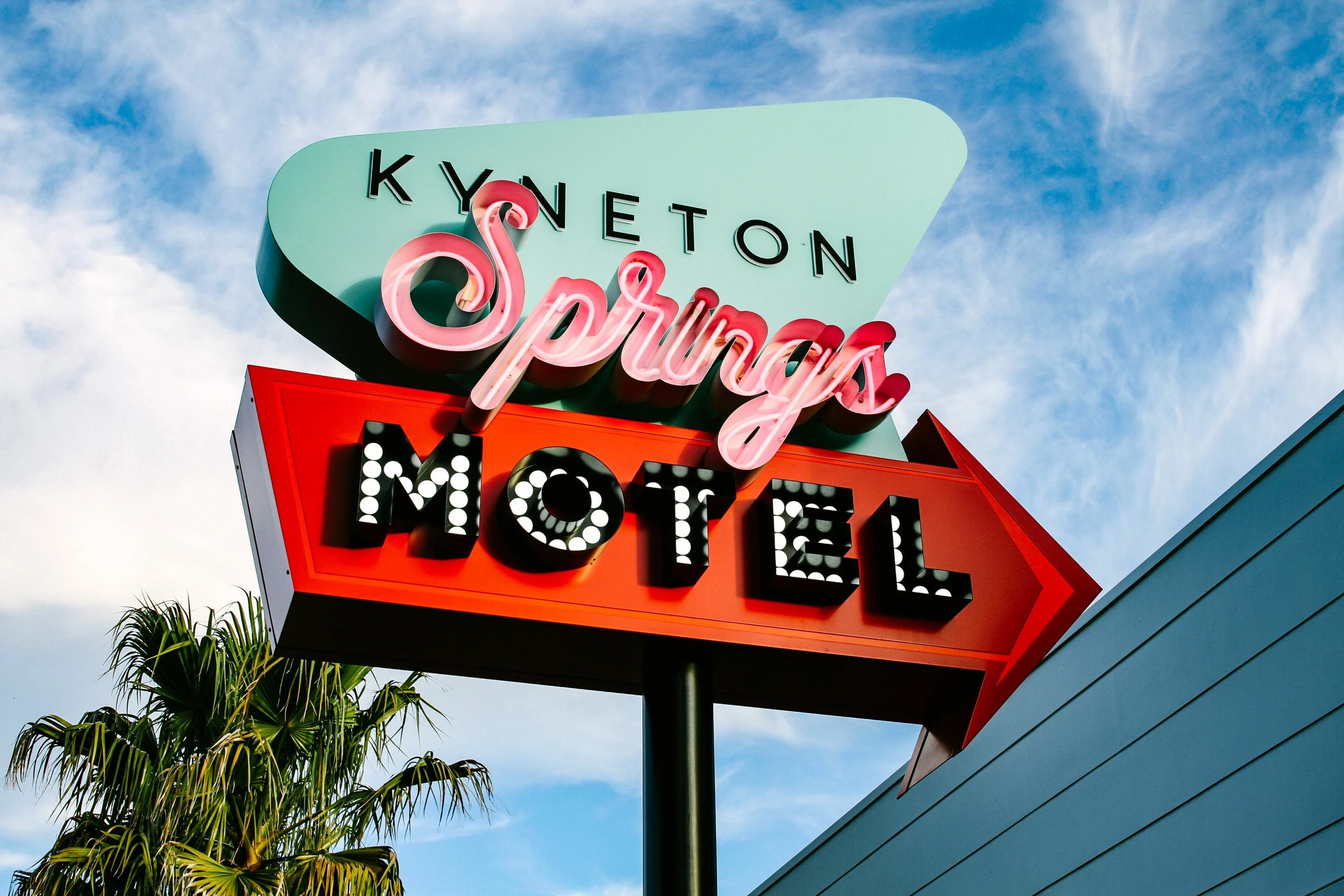 A neon blue, red and pink sign for Kyneton Springs Motel.