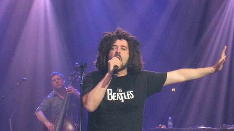 The lead singer of the Counting Crows singing on stage.