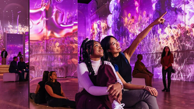 Two people sitting and looking at an exhibit.