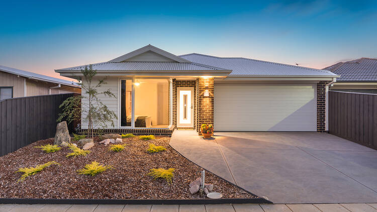 A small suburban home with a long driveway.